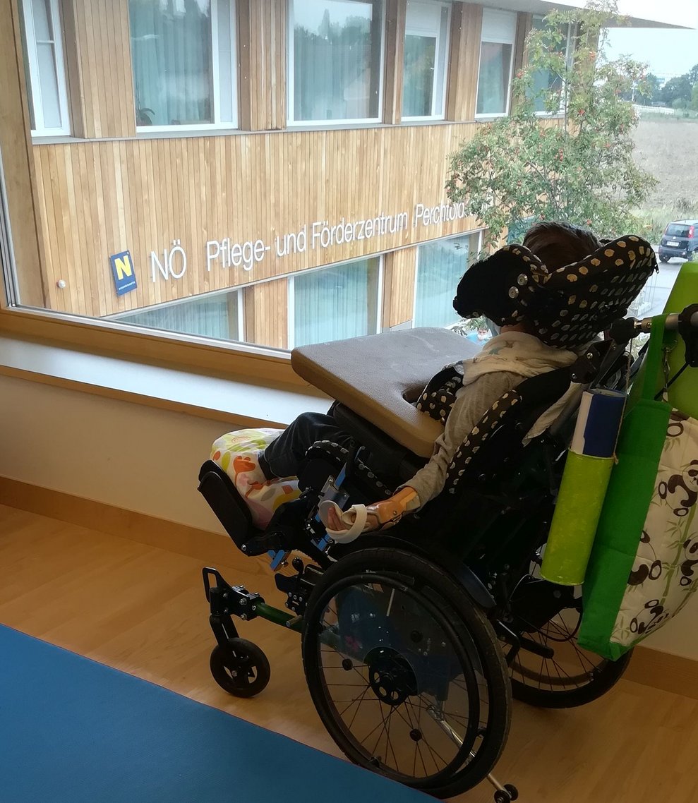 Klient sitzt im Rollstuhl und blickt aus dem Fenster