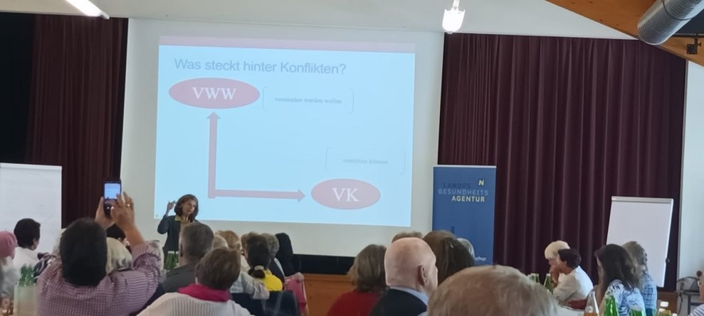 EA-Fortbildung: Frau redet, Dia-Vortrag auf Leinwand.